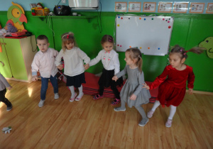 Dzieci trzymają się za ręce tańcząc w kole